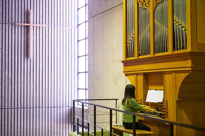 チャペルでパイプオルガンを演奏する学生